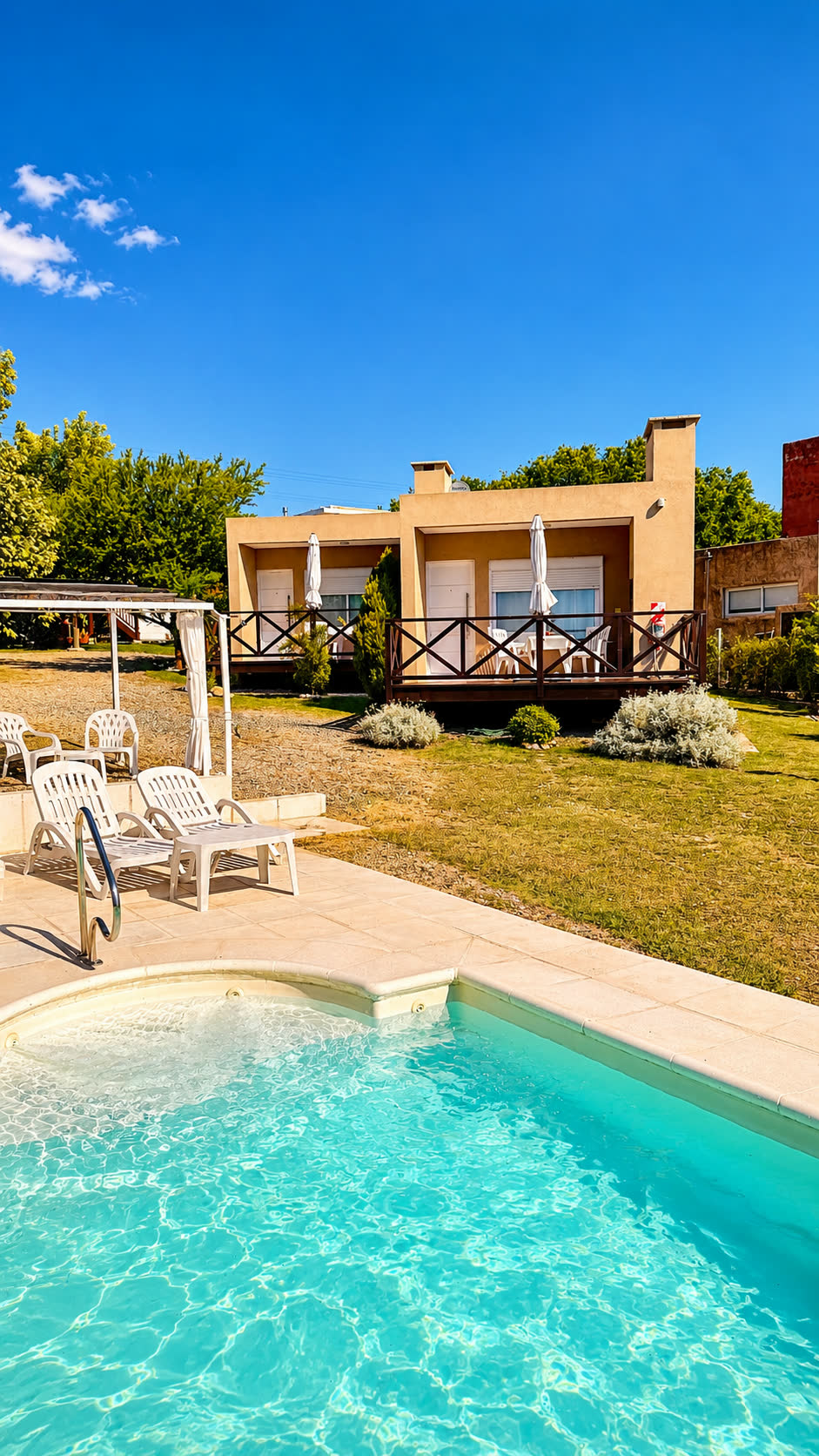 La piscina descubierta con las dos suites al fondo